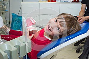 A happy girl with a jaw mock in a dentistÃ¢â¬â¢s office photo